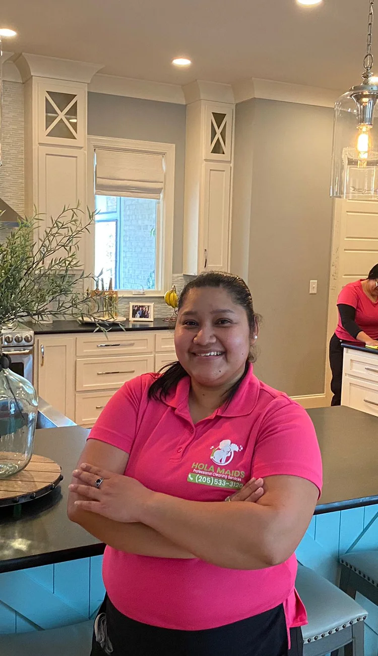 Maria Eduarda, founder of Hola Maids, in a pink Hola Maids uniform